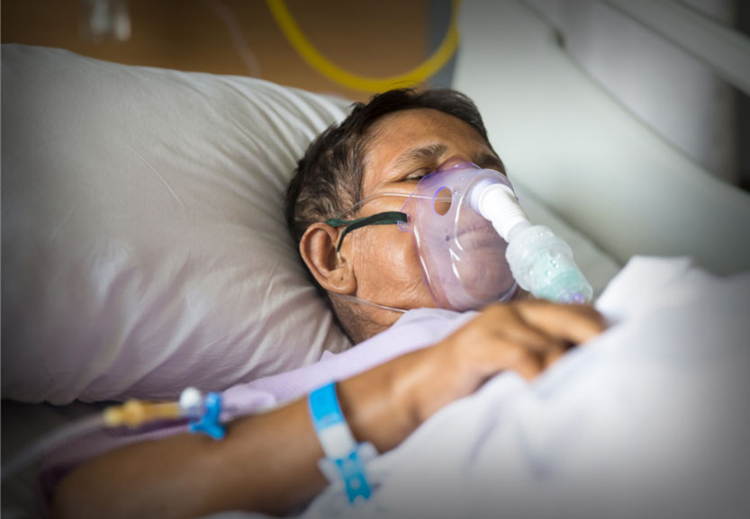 Old woman with ventilator mask on hospital bed