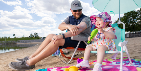 father and toddler on the beach practicing sun safety