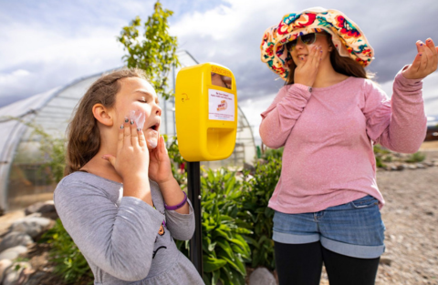 two girls putting on sunscreen at Urban Roots farm
